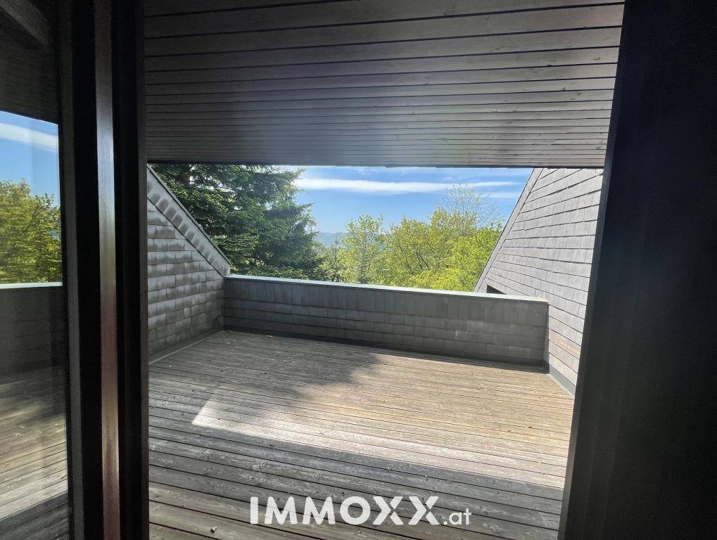 Weitläufige Holzterrasse mit Blick auf die umliegende Natur und den Himmel.