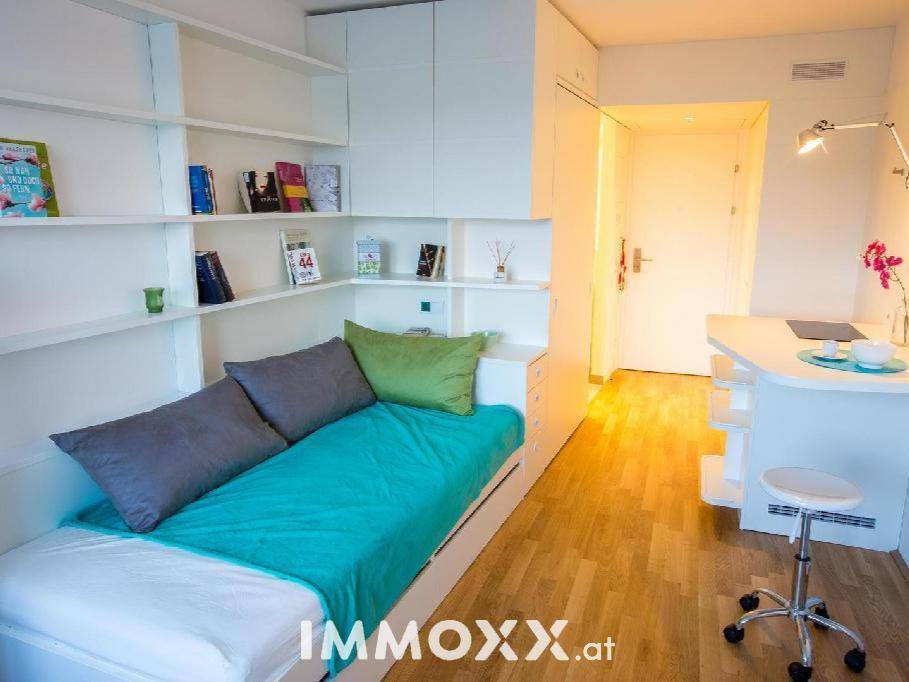 Helles Studio-Apartment mit Holzboden, Bett und Schreibtisch, ideal für Studenten oder Singles.