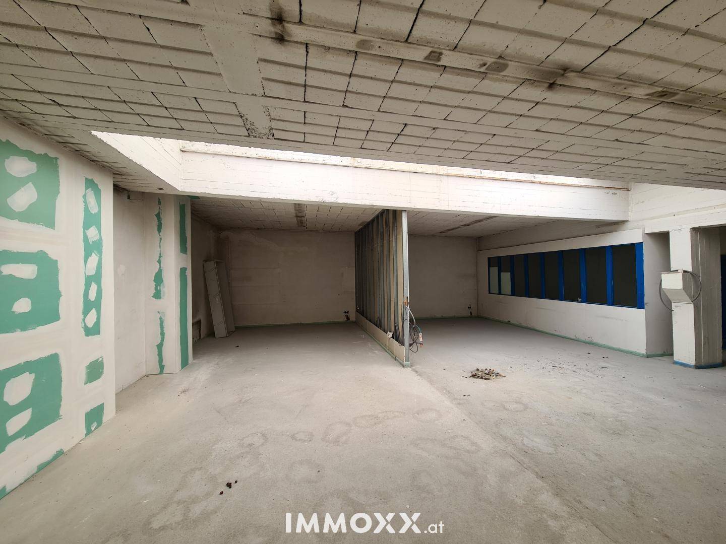 Unfertiger Innenraum mit Rohbauwänden und Betonboden, bereit für den Ausbau.