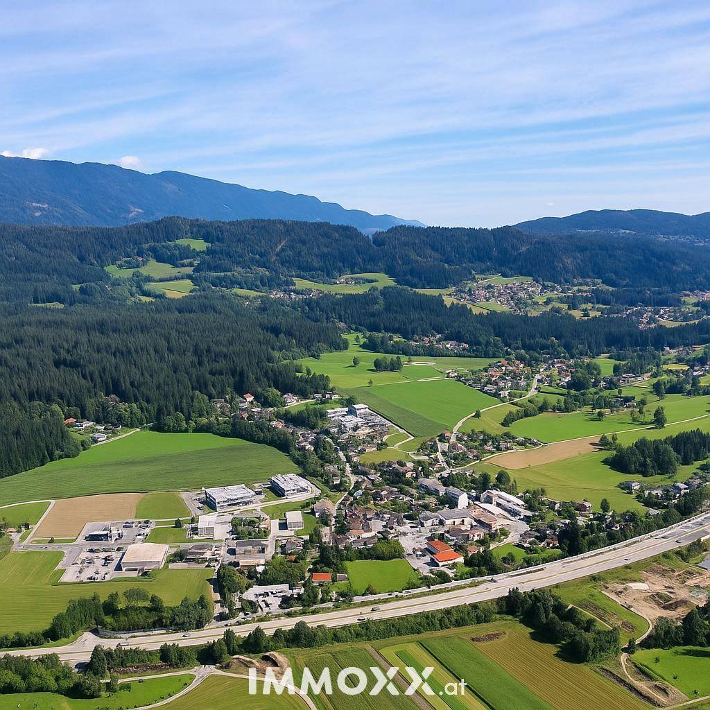 Luftaufnahme einer weitläufigen Landschaft mit Feldern, Wäldern, einer Autobahn und Bergszenerie.