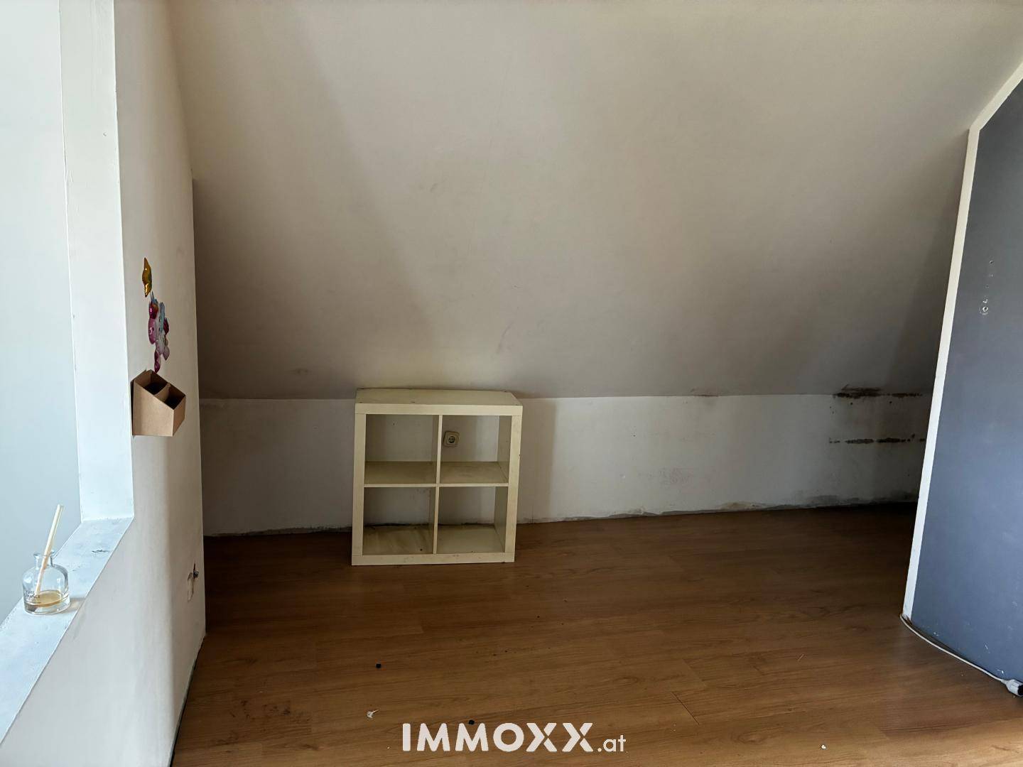 Weiteres Dachgeschosszimmer mit Laminatboden und schrägen Wänden.