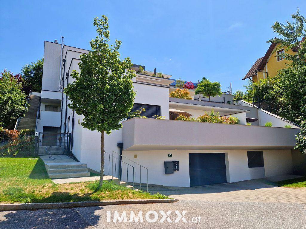 Moderne Architektur des Gebäudes mit Terrassen und integrierter Garage.