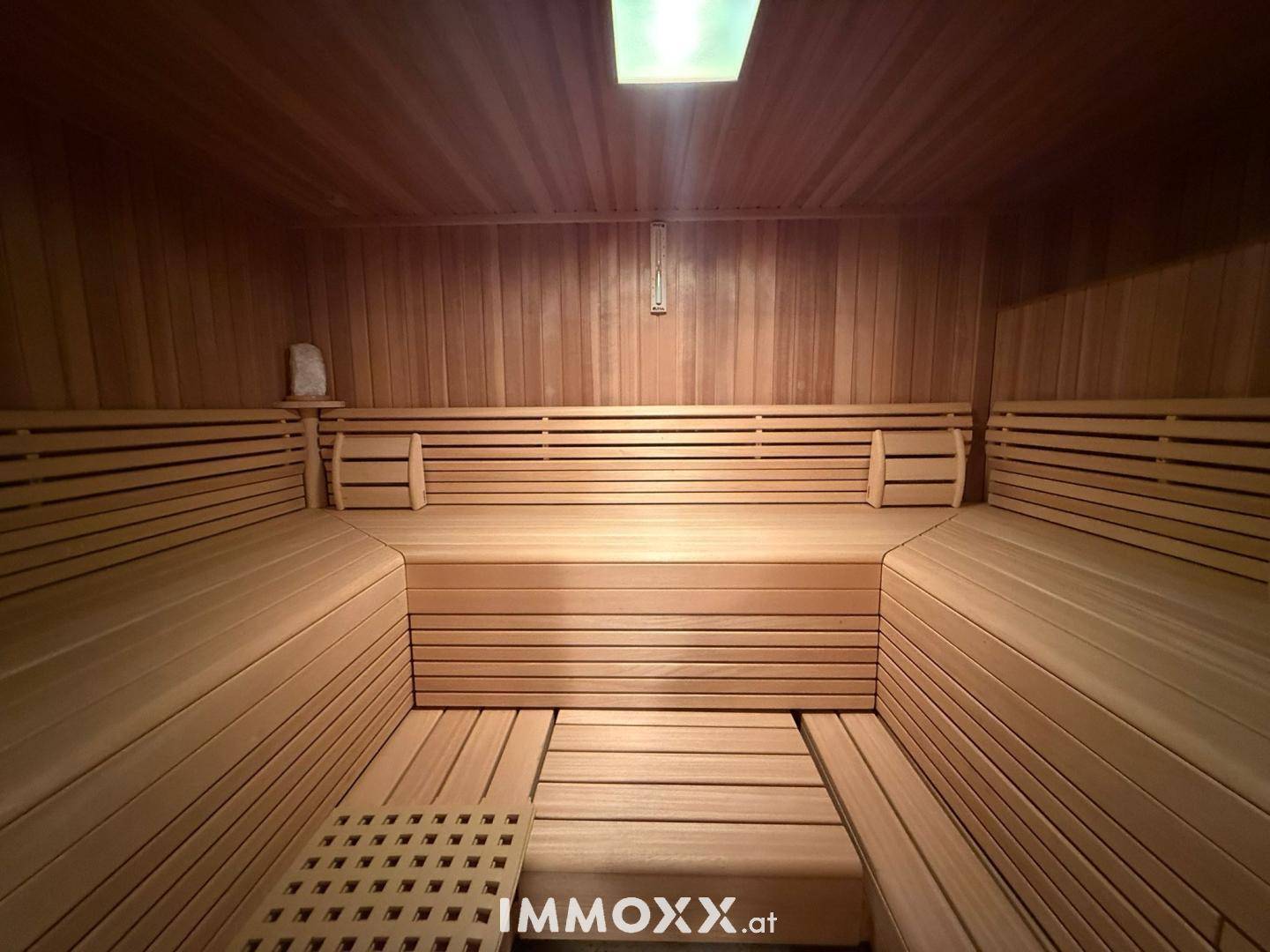 Geräumige Holzsauna mit mehreren Bänken für entspannende Wellness-Momente.