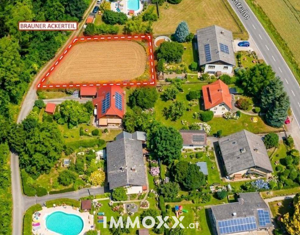 Luftaufnahme eines Wohngebiets mit mehreren Häusern, Pools und einem markierten Grundstück.