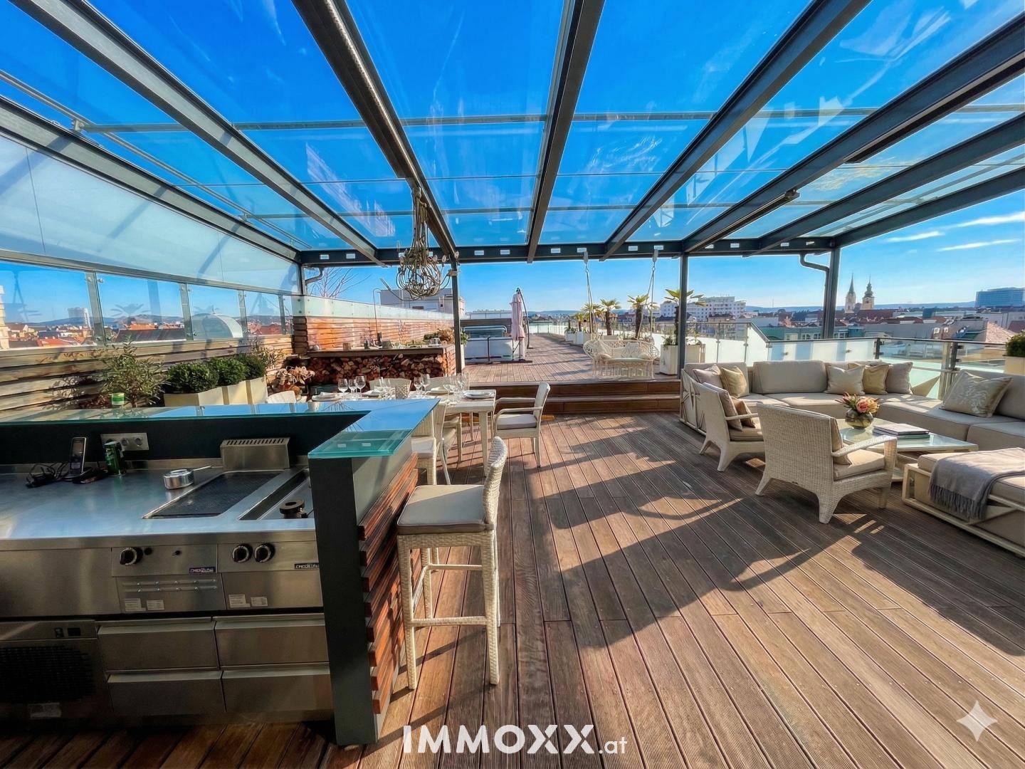 Luxuriöse Dachterrasse mit Glasüberdachung, Außenküche und Lounge-Bereich.