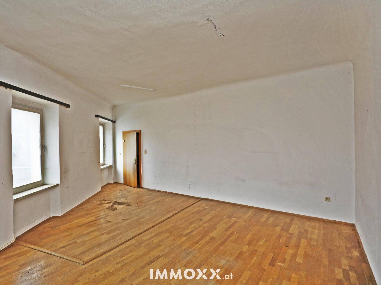 Heller, unmöblierter Raum mit Holzboden und einer Tür, ideal für individuelle Gestaltung.