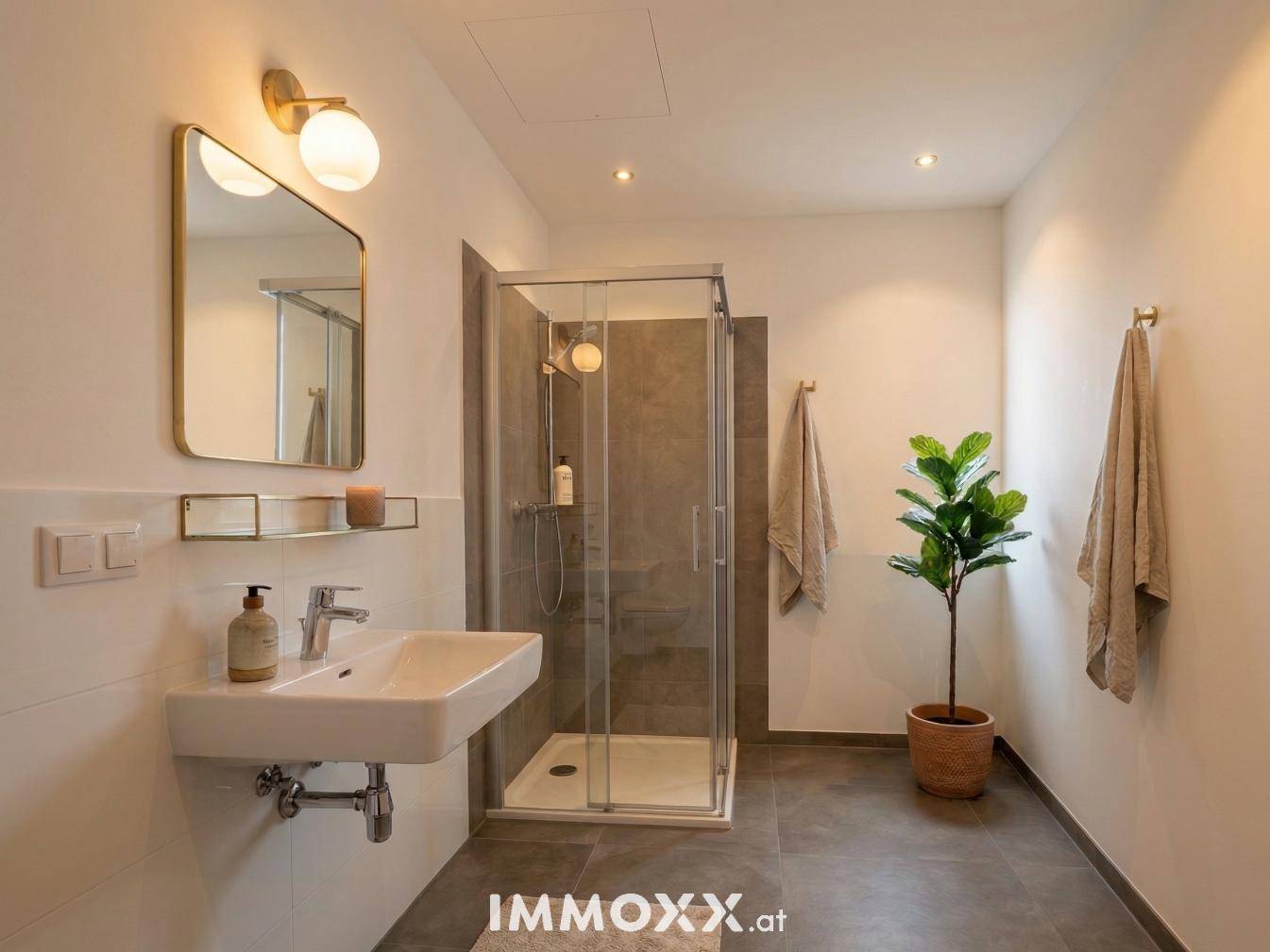 Modernes Badezimmer mit Duschkabine, Einzelwaschbecken und stilvoller Beleuchtung.