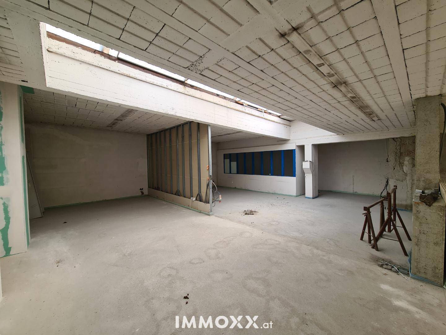 Großzügiger Rohbau-Raum mit Betonstruktur und natürlicher Belichtung durch das Dachfenster.