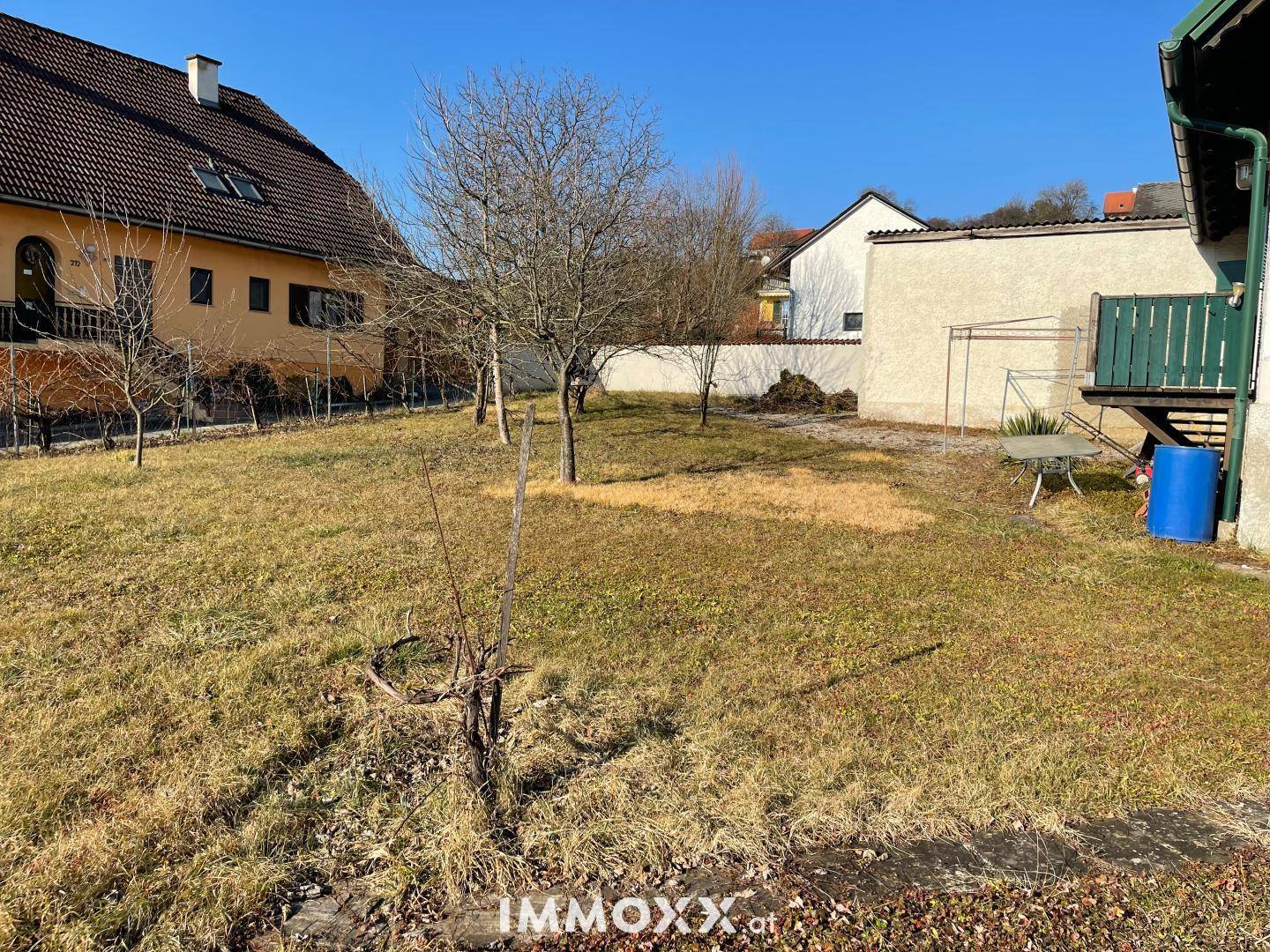 Großer Gartenbereich mit Rasenfläche und einigen kahlen Bäumen, bereit zur Gestaltung.