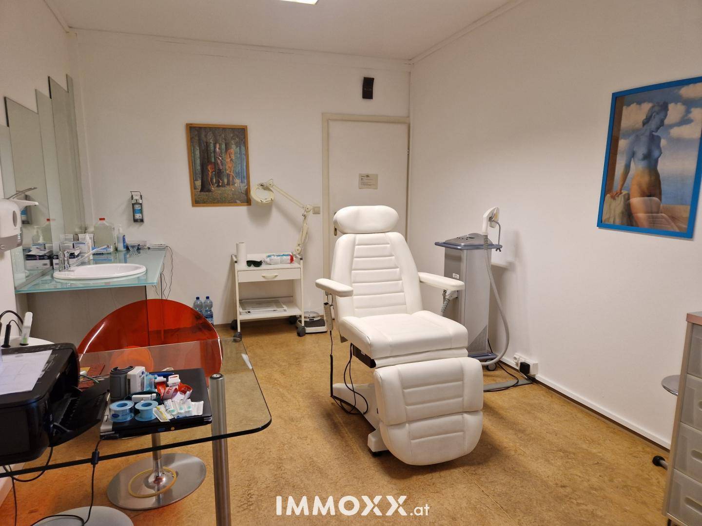 Behandlungszimmer mit medizinischem Stuhl, Waschbecken und Geräten in einem hellen Raum.