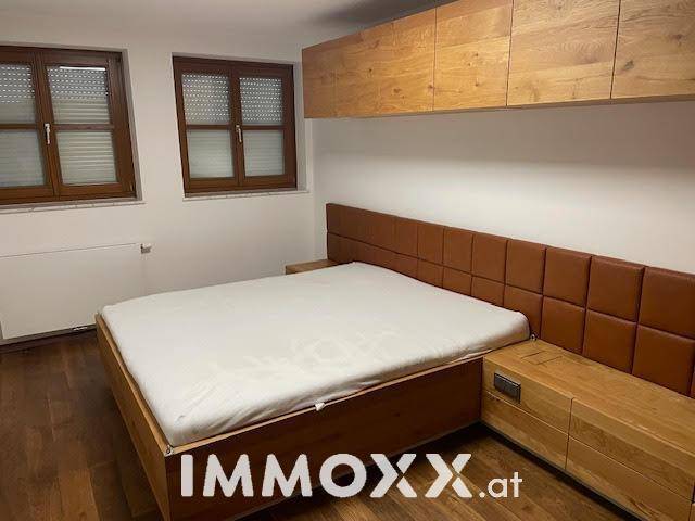 Gemütliches Schlafzimmer mit Holzbett, passenden Nachttischen und integrierten Holzschränken.