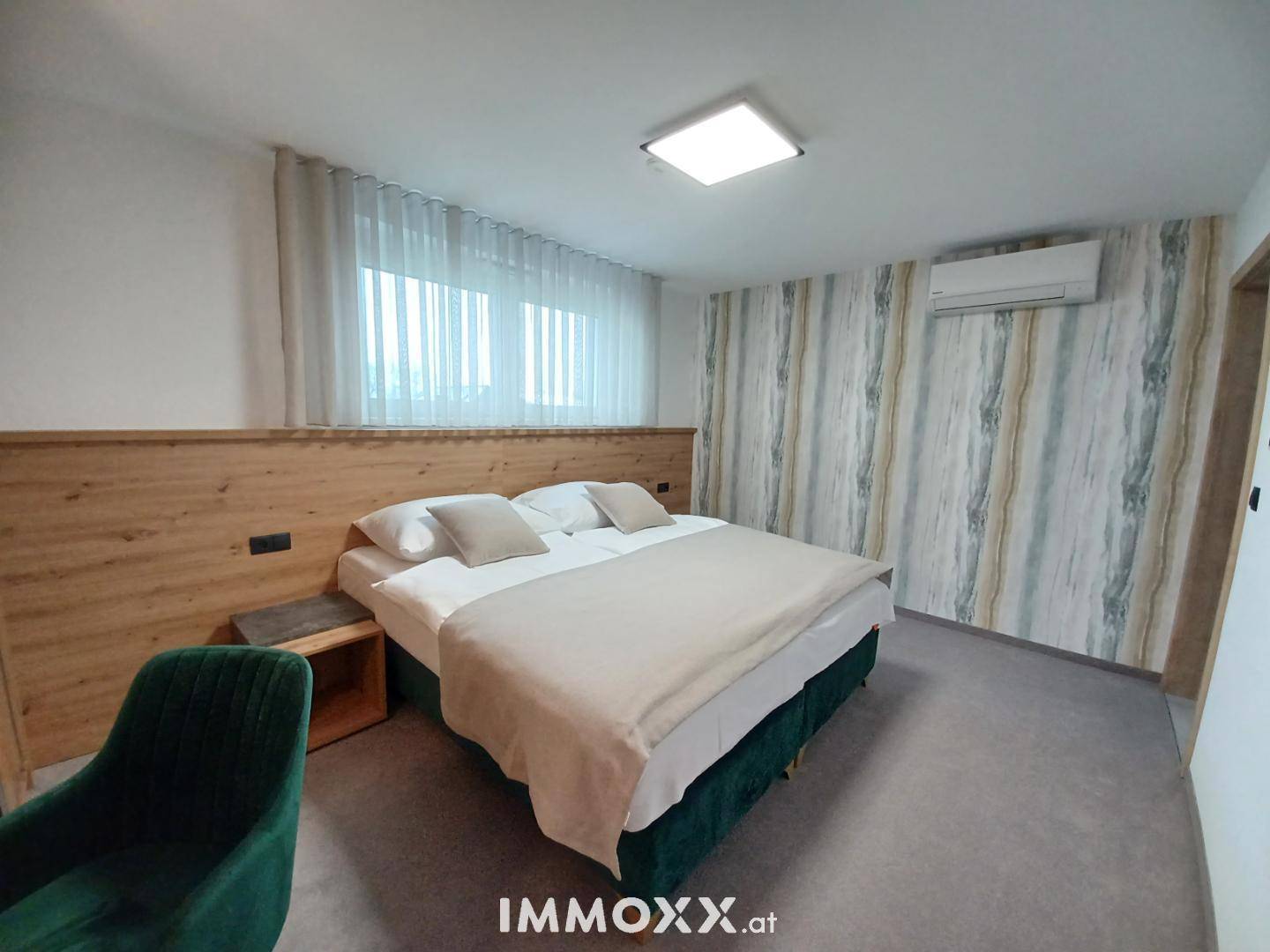 Gemütliches Schlafzimmer mit Doppelbett, Akzentwand und Klimaanlage für Komfort.