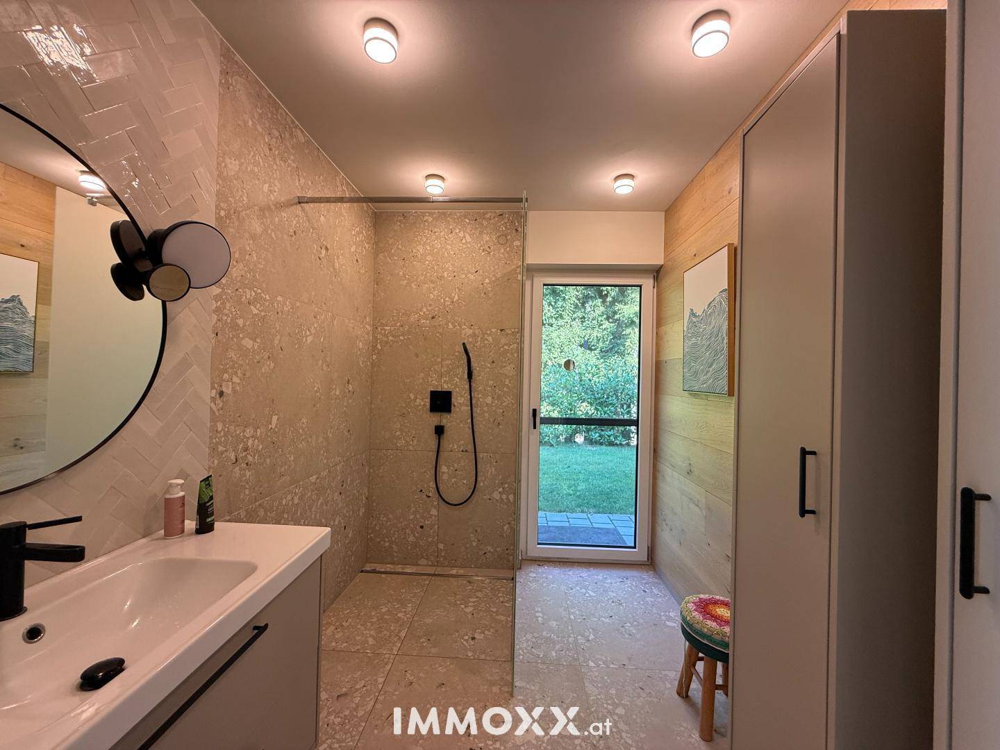 Modernes Badezimmer mit begehbarer Dusche, Einzelwaschbecken und direktem Zugang zum Garten.