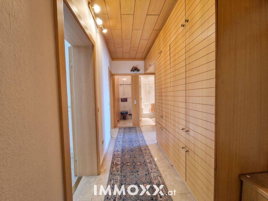 Langer Flur mit Holzvertäfelung an Decke und Wänden sowie praktischen Einbauschränken.
