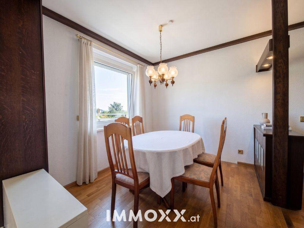 Gemütlicher Essbereich mit Holztisch und Stühlen, umgeben von hellen Wänden und einem Fenster.