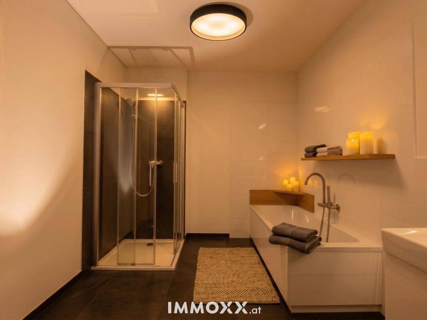 Modernes Badezimmer mit Badewanne, Duschkabine und dunklen Bodenfliesen, stimmungsvoll beleuchtet.