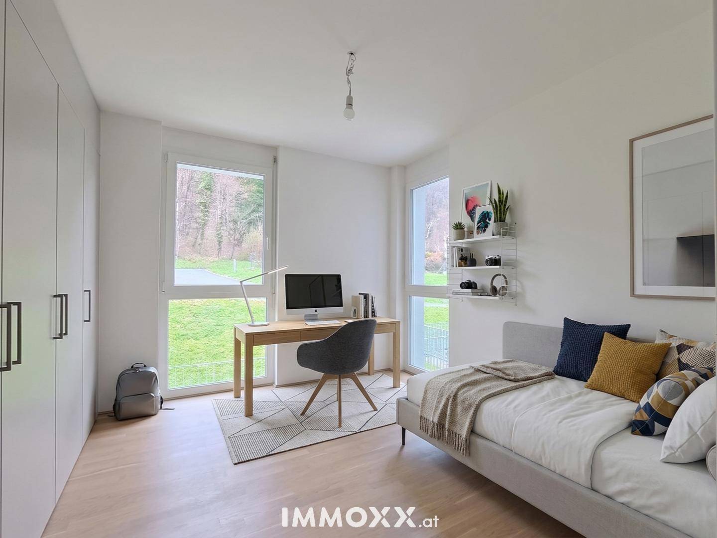 Helles Zimmer, als Büro oder Gästezimmer nutzbar, mit großem Fenster, Schrank und Holzboden.