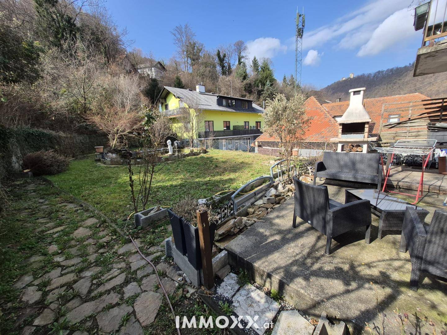 Gemütliche Terrasse mit Sitzgelegenheiten und Blick auf den Garten und die umliegende Landschaft.