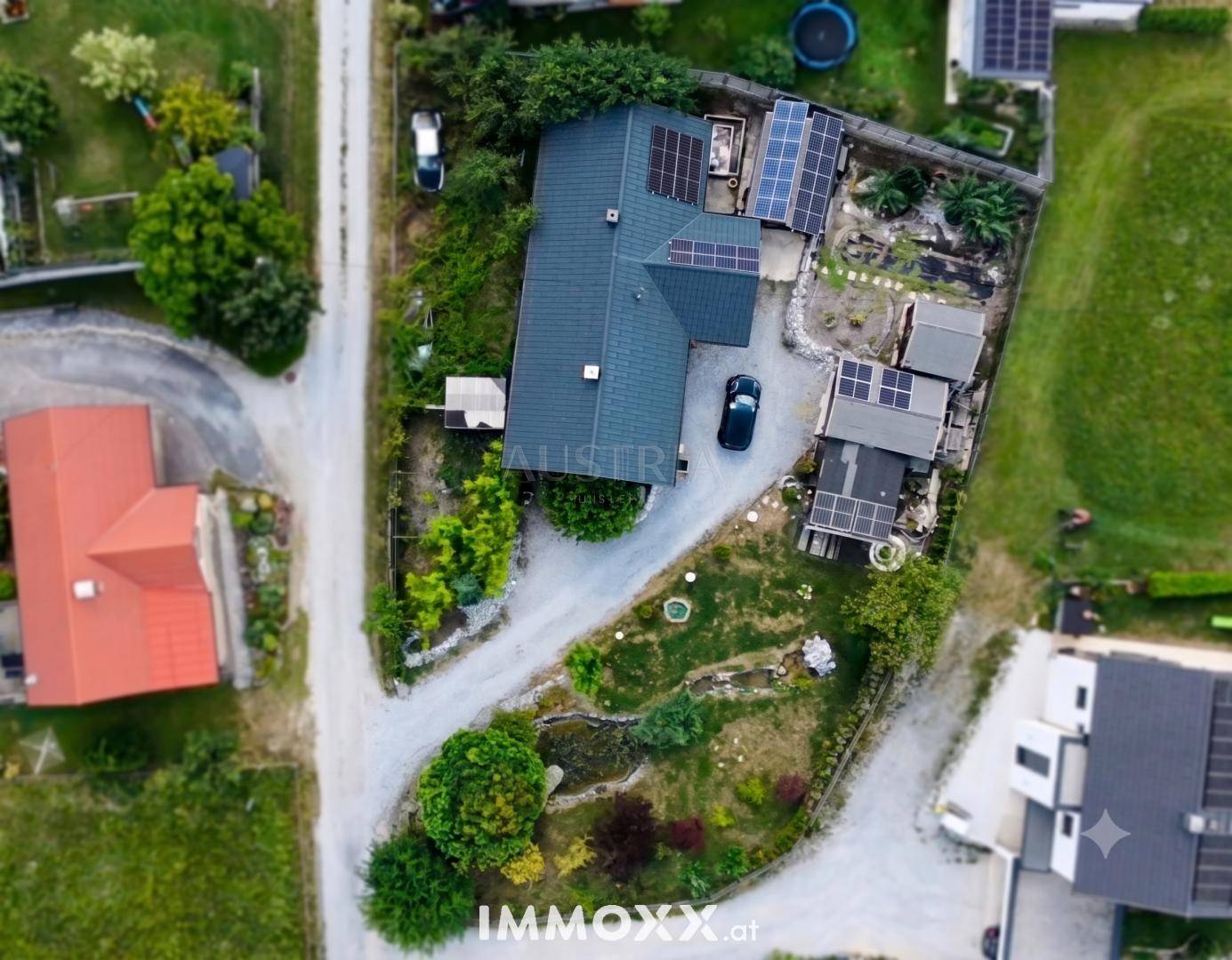 Draufsicht auf das Grundstück mit Wohnhaus, Nebengebäuden und Photovoltaikanlage auf dem Dach.