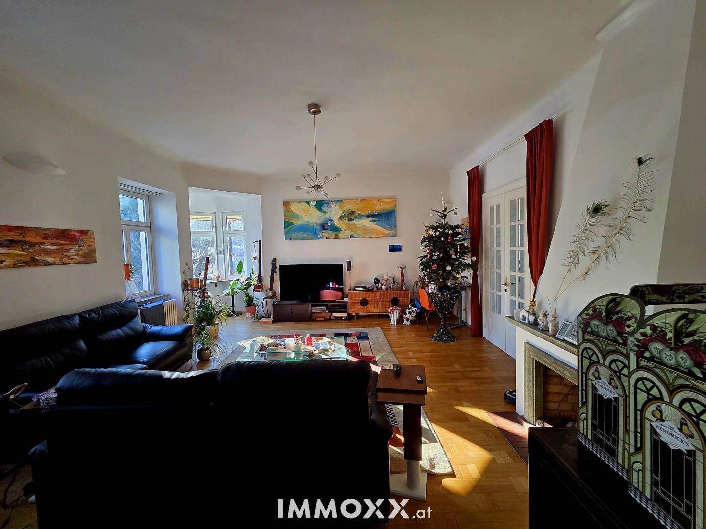 Gemütliches Wohnzimmer mit Parkettboden, Kamin und festlicher Dekoration.