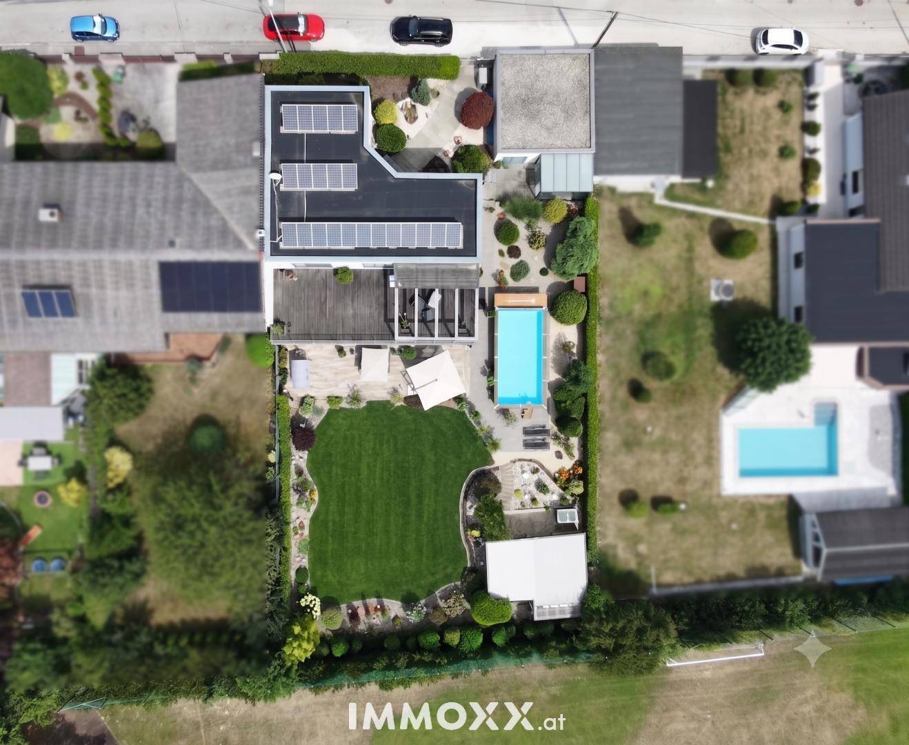 Draufsicht des Grundstücks mit Haus, Pool, Garten und Solaranlage auf dem Dach.