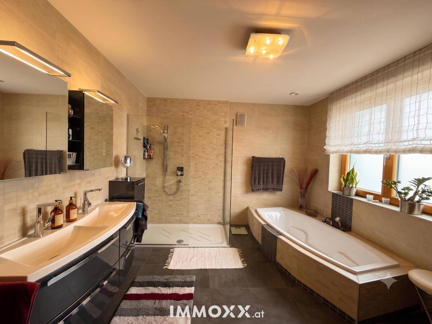 Elegantes Badezimmer mit Doppelwaschbecken, großer Dusche und Badewanne.