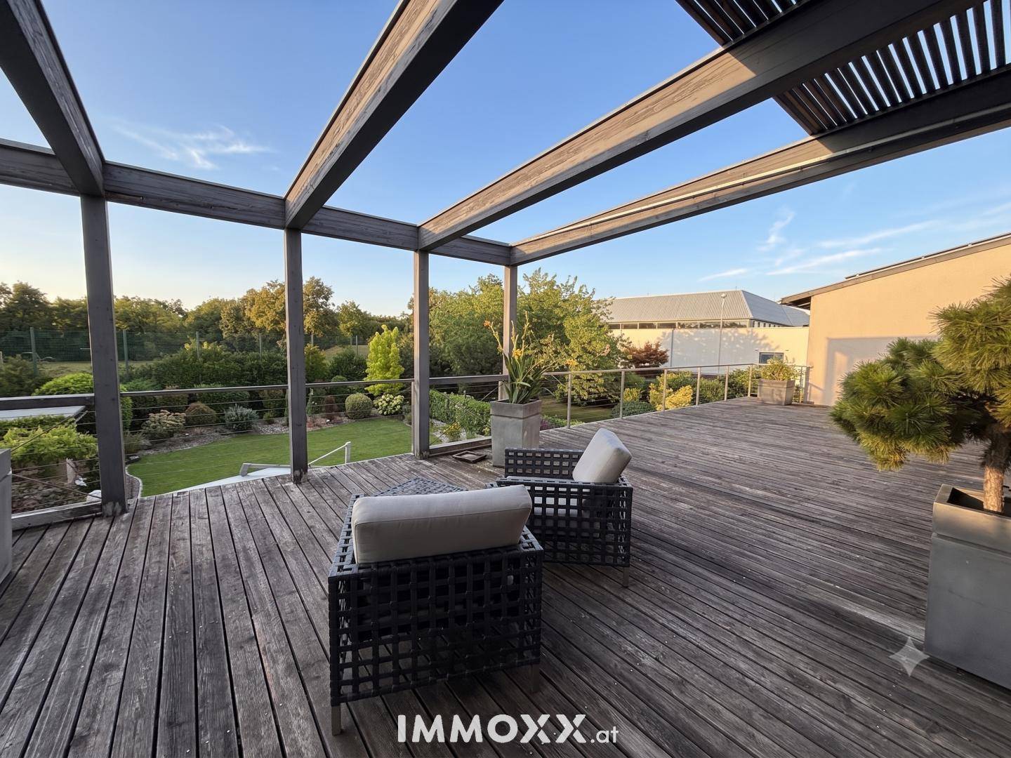Große Dachterrasse mit Holzbelag und Loungemöbeln, bietet weite Ausblicke.