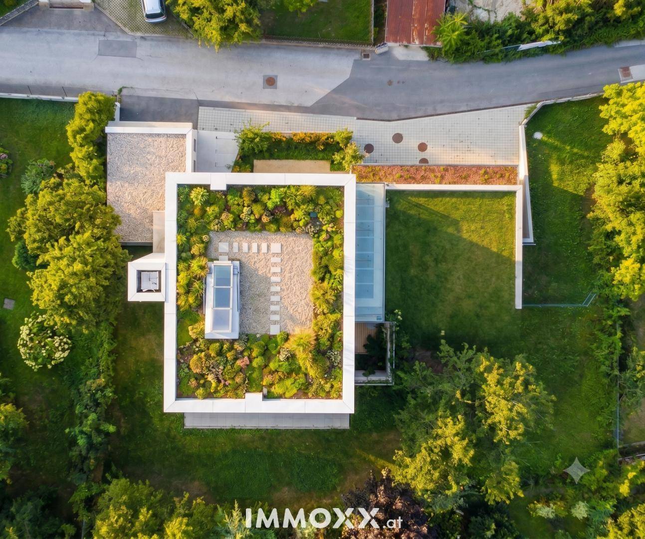 Draufsicht auf das moderne Gebäude mit extensiver Dachbegrünung und Gartenanlage.