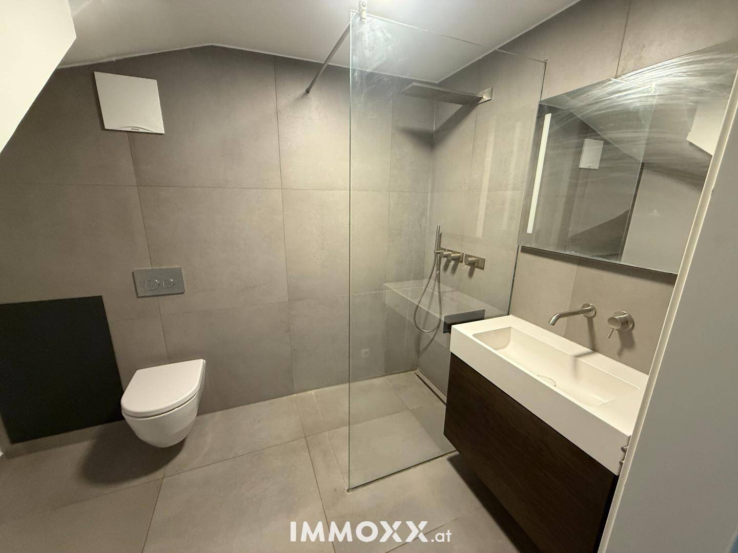 Helles modernes Badezimmer mit begehbarer Dusche, Wand-WC und elegantem Waschtisch.