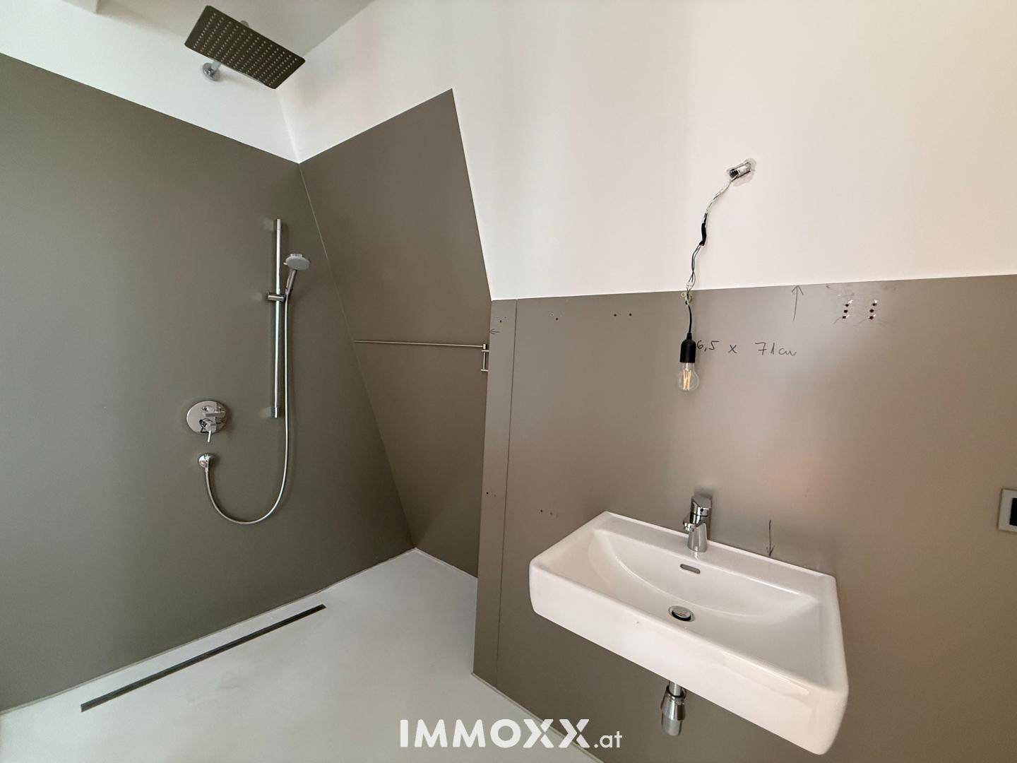 Modernes Badezimmer im Bau mit begehbarer Dusche, Regenduschkopf und Einzelwaschbecken.