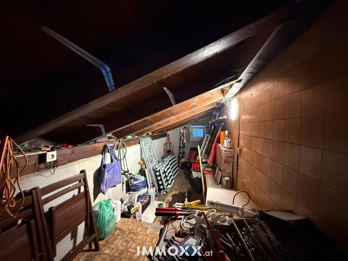 Unausgebauter Dachboden mit sichtbaren Holzbalken, genutzt als Abstellraum.