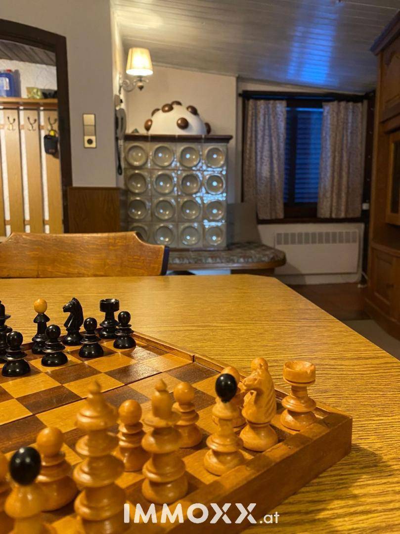 Detailansicht eines Schachbretts auf einem Holztisch im traditionellen Wohnbereich.