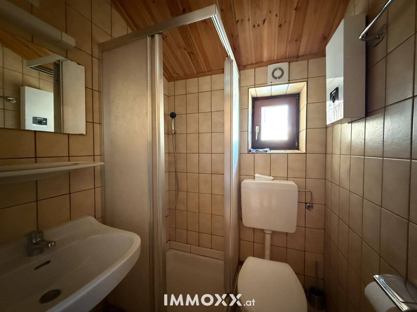 Kleines Badezimmer mit Dusche, WC, Waschbecken und gefliesten Wänden im traditionellen Stil.