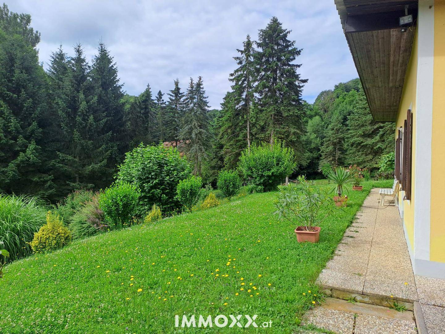 Großer, gepflegter Gartenbereich neben dem Haus mit einer Terrasse und weitem Blick ins Grüne.