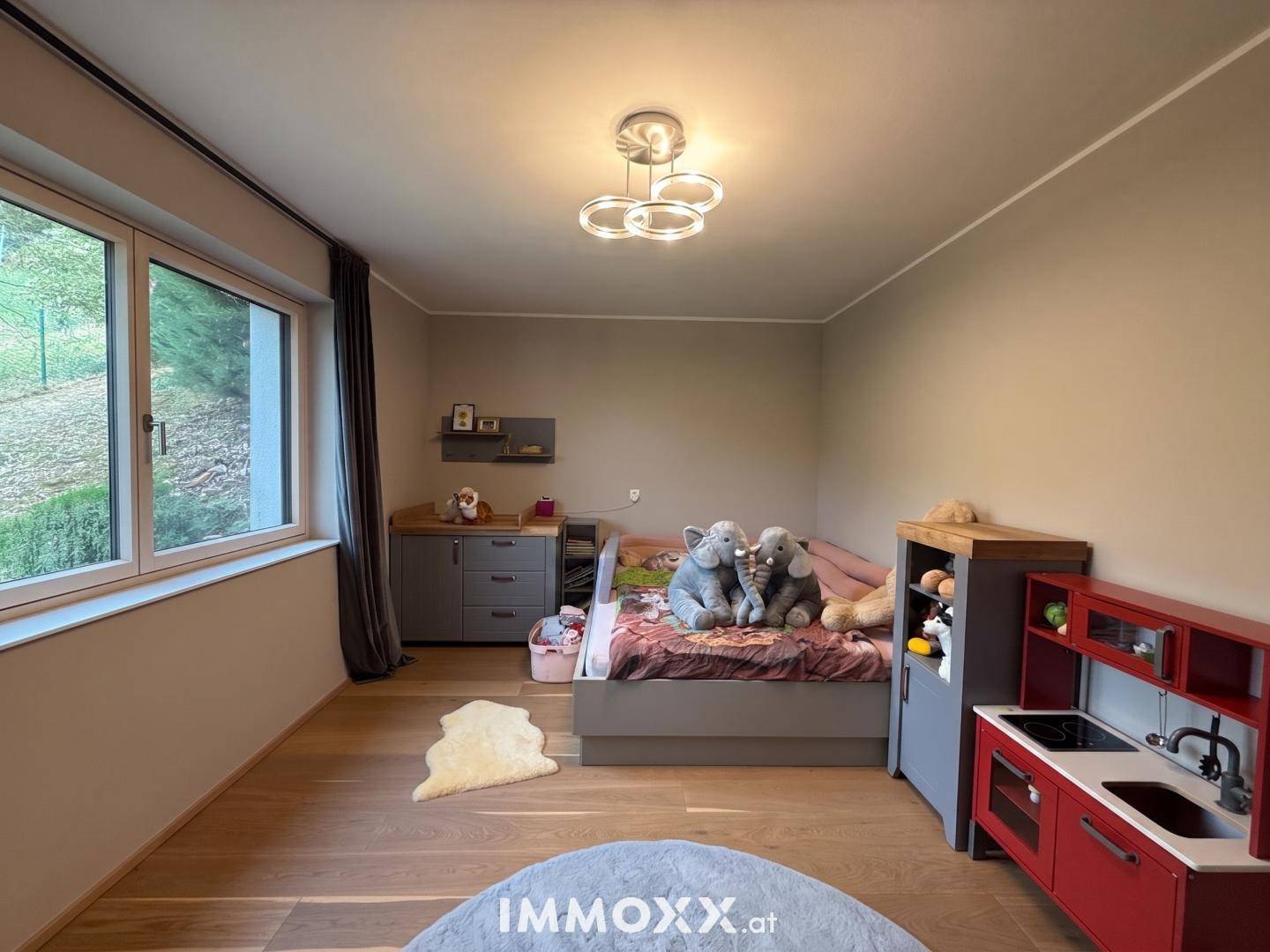 Kinderzimmer mit Bett, Spielzeug und einer kleinen Spielküche, ideal für junge Bewohner.
