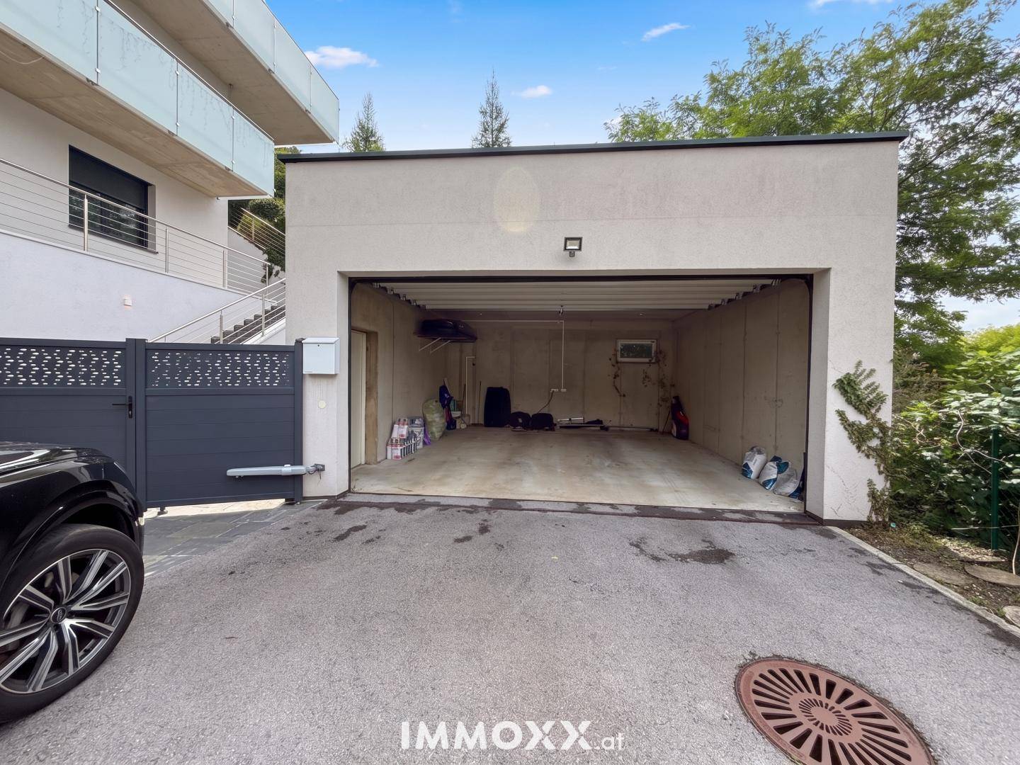 Geräumige Doppelgarage mit offenem Tor, bietet Platz für Fahrzeuge und zusätzlichen Stauraum.