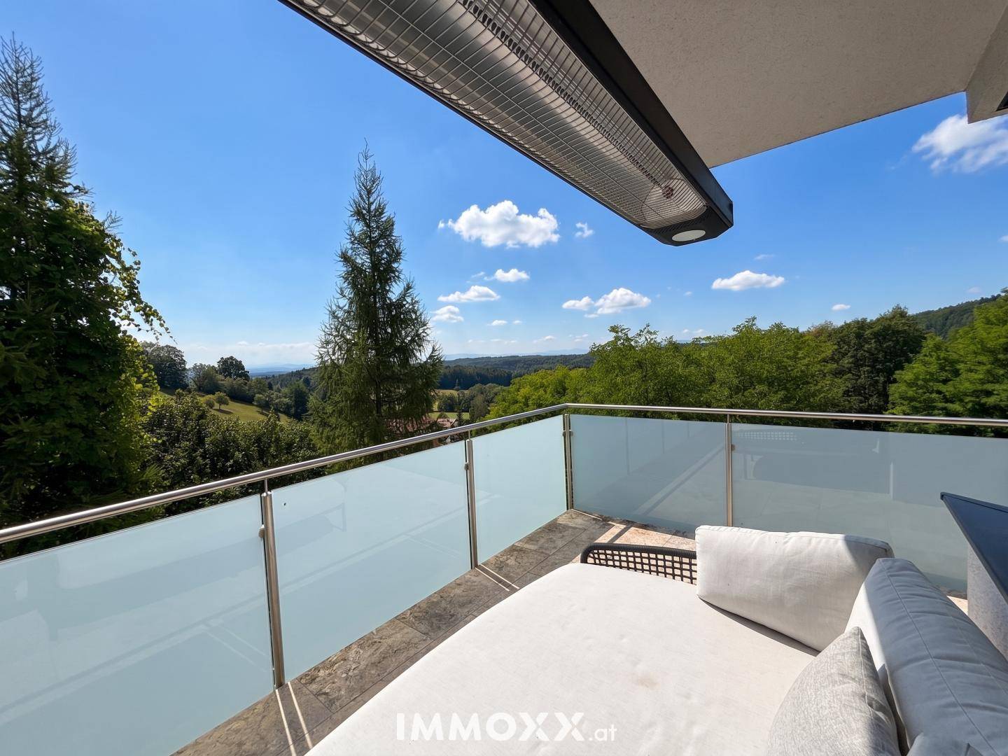 Geräumiger Balkon mit bequemen Möbeln und einem weiten Blick über die grüne Landschaft.