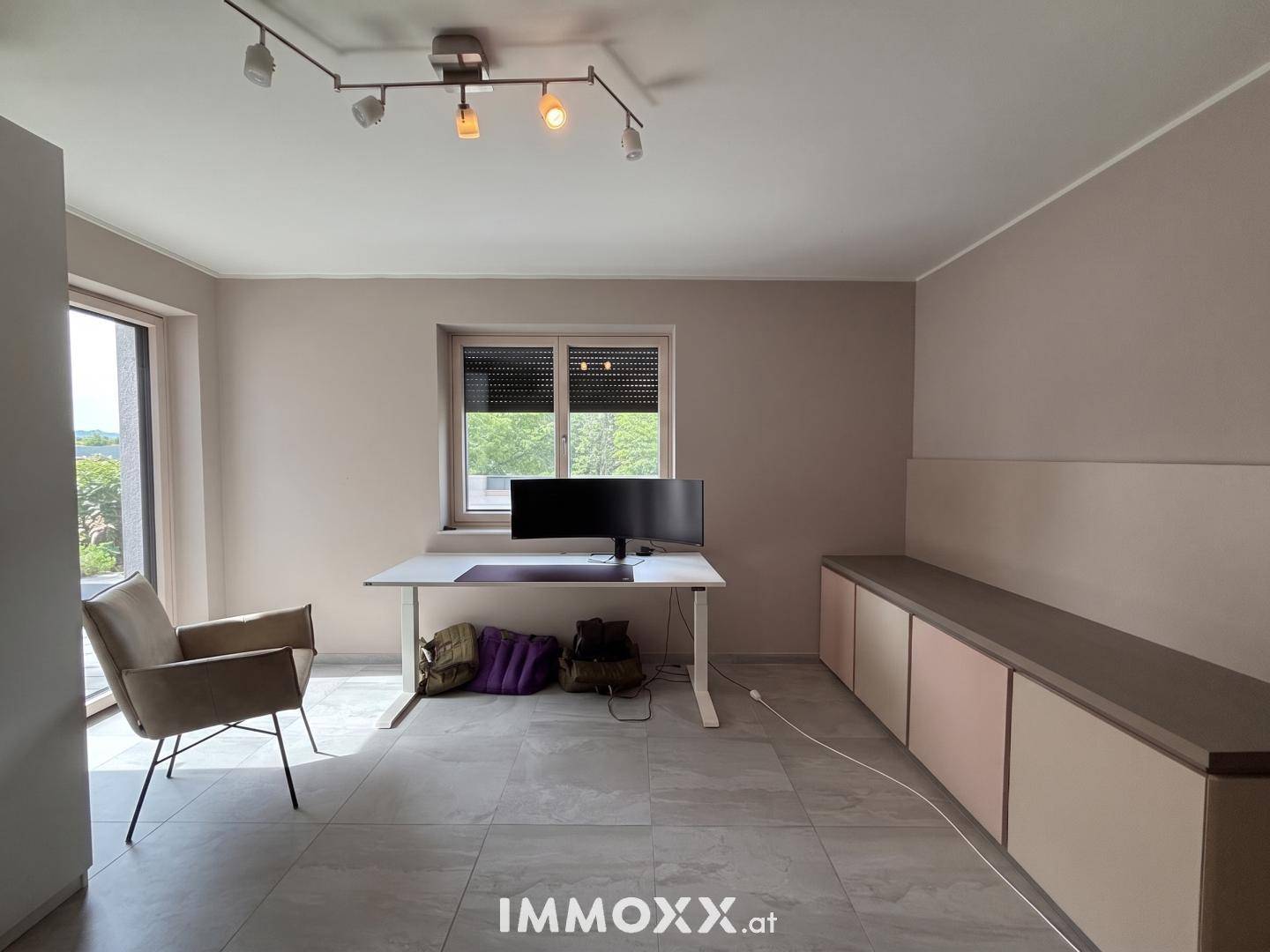 Funktionales Büro mit Schreibtisch, Stuhl und praktischen Einbauschränken.