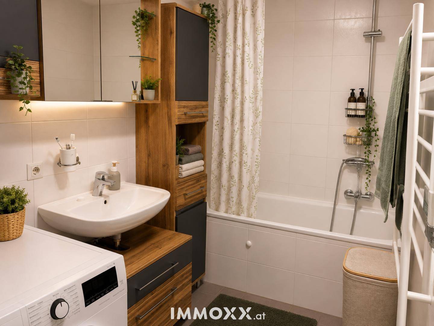 Helles Badezimmer mit Badewanne, Dusche, Waschbecken und Handtuchheizkörper.