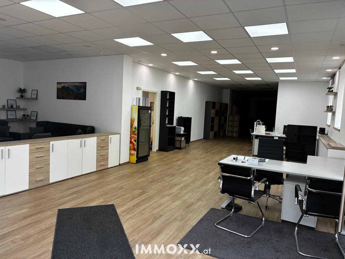 Großes, offenes Büro mit mehreren Arbeitsbereichen, Stauraum und einem Getränkeautomaten.