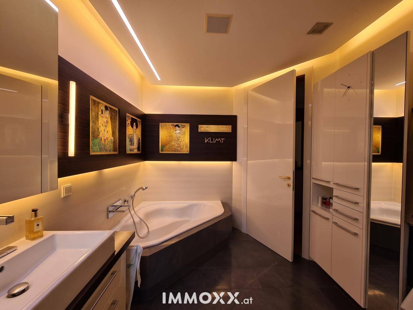 Modernes Badezimmer mit Eckbadewanne, eleganten weißen Schränken und stimmungsvoller Beleuchtung.