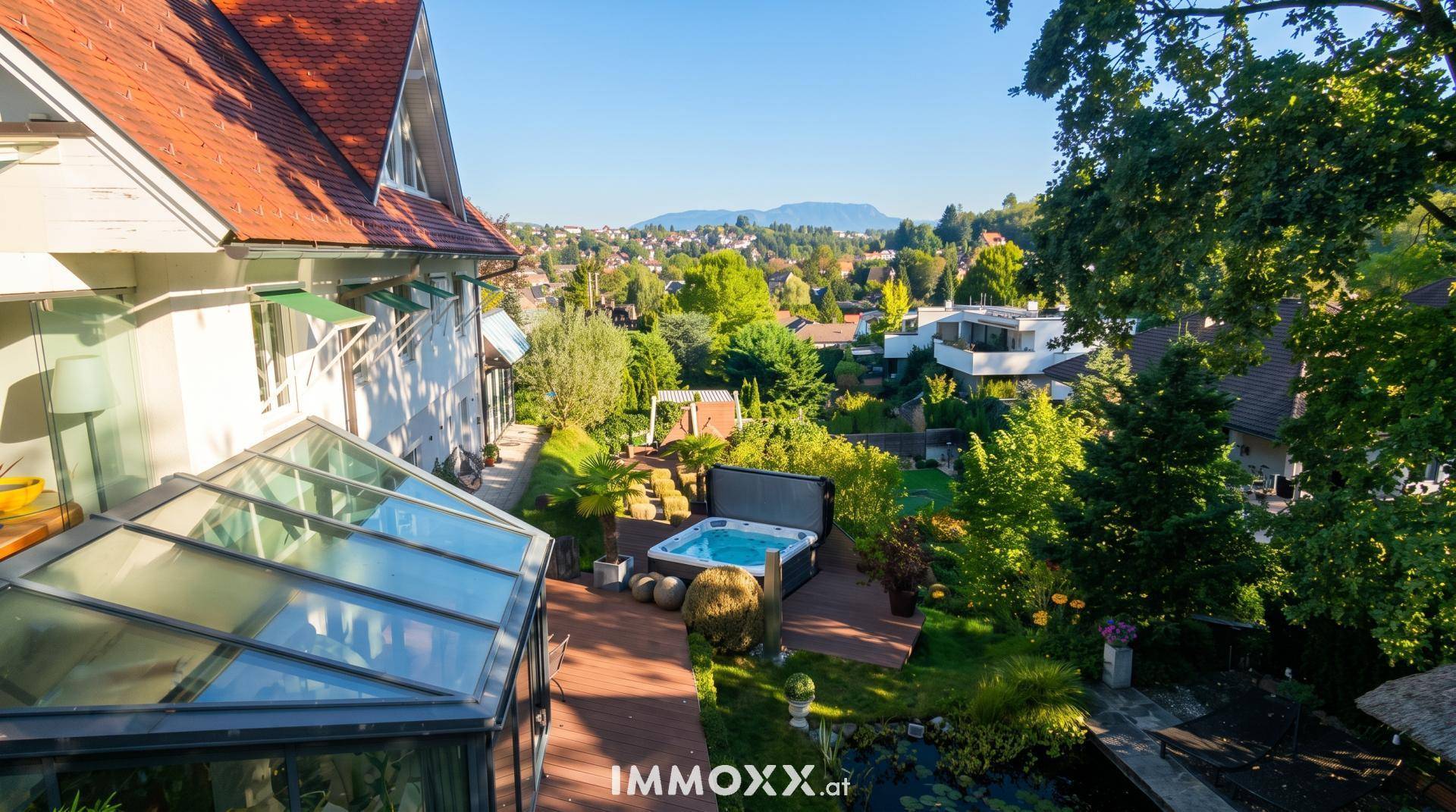 Terrasse mit Whirlpool und Glasüberdachung, umgeben von Grünflächen mit weitem Stadtblick.