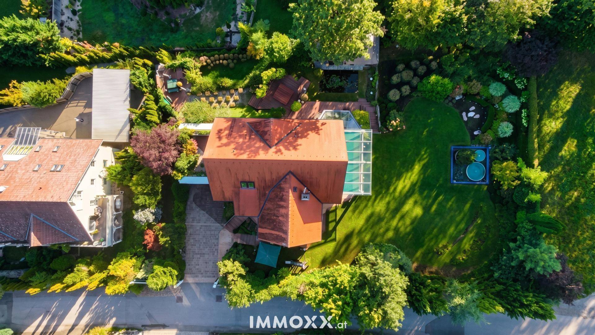 Vogelperspektive des Anwesens mit weitläufigem Garten, Poolbereich und angrenzenden Grundstücken.