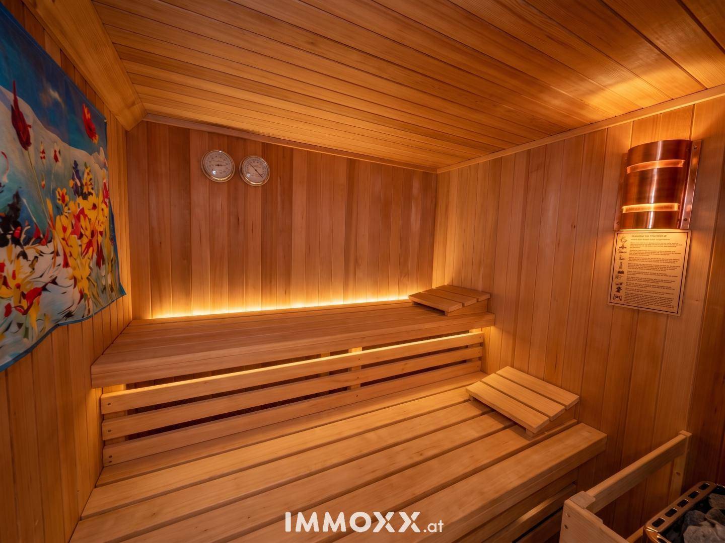 Gemütliche Holzsauna mit Bänken und indirekter Beleuchtung für entspannende Momente.