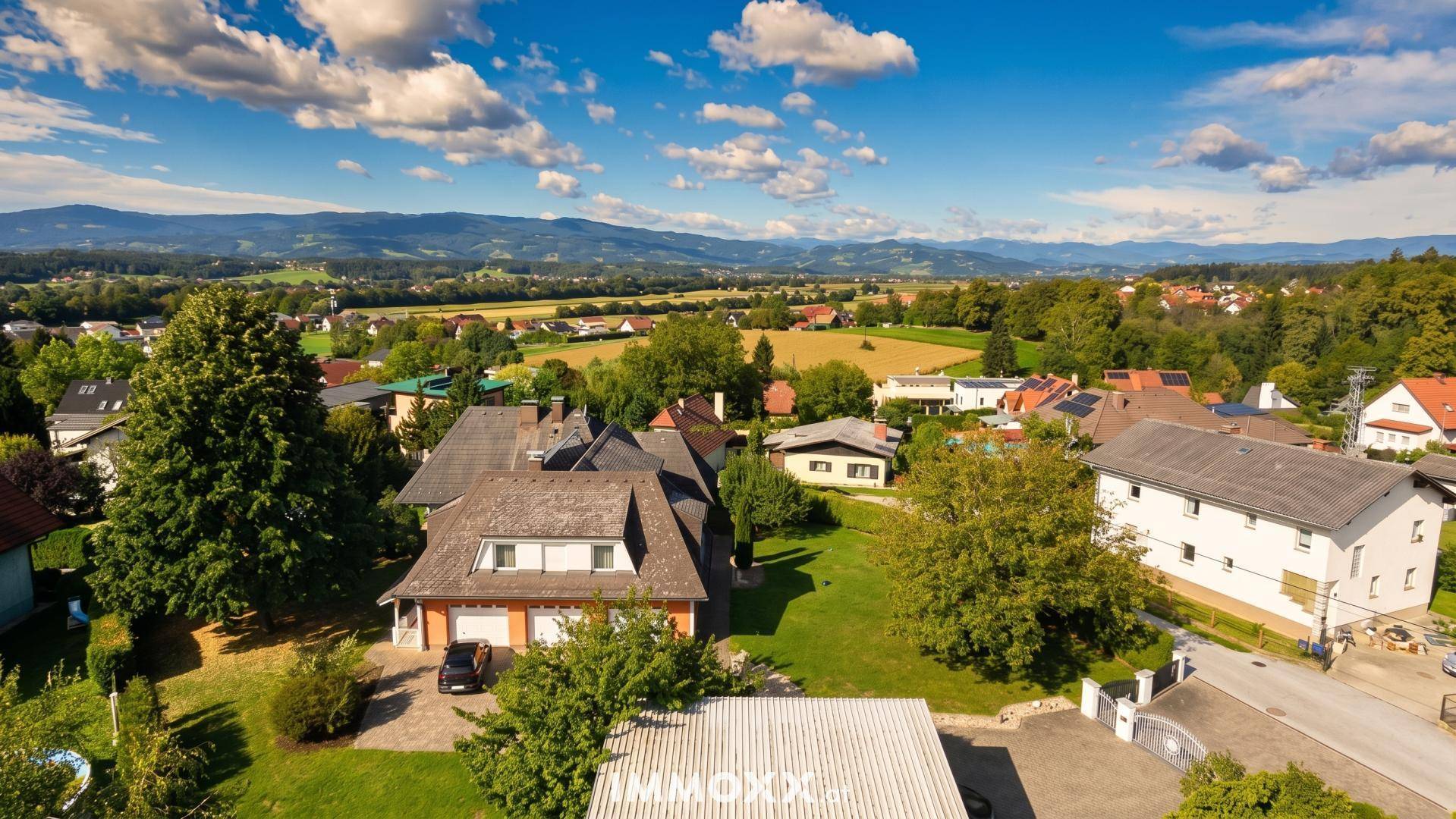 Weitläufiges Anwesen mit großem Garten und Blick auf die umliegende Landschaft und Berge.