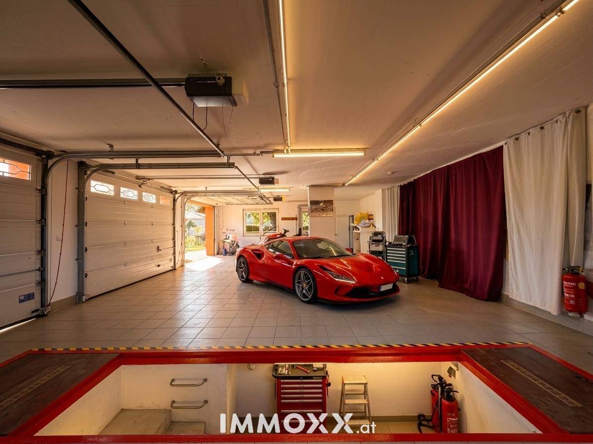 Große Garage mit Hebebühne und Platz für mehrere Fahrzeuge.