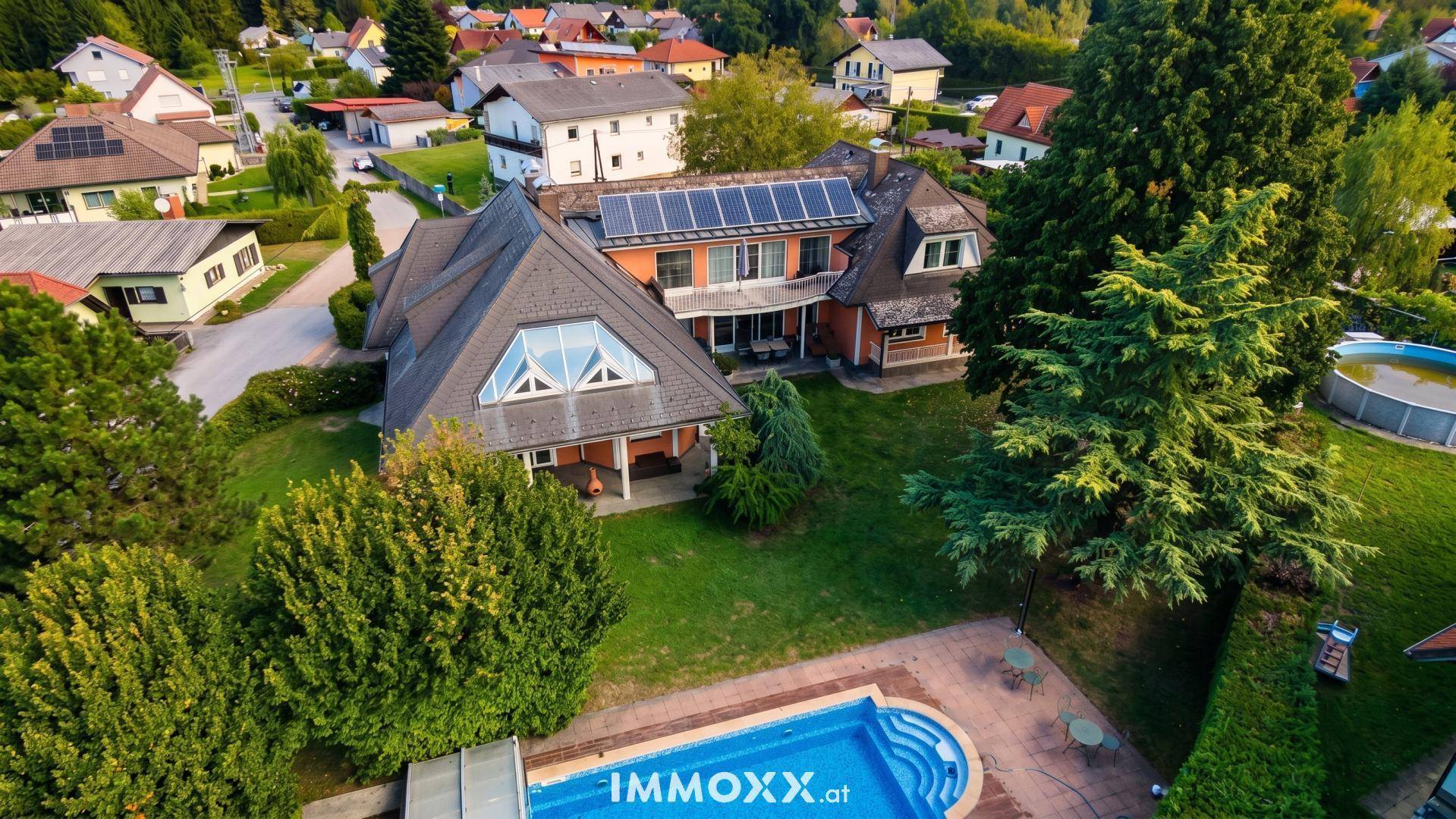 Großzügiger Gartenbereich mit Swimmingpool und weitläufiger Rasenfläche vor dem Haus.