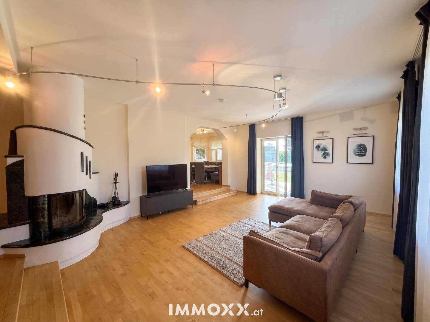 Helles Wohnzimmer mit Holzboden, modernem Kamin und Zugang zum Garten.
