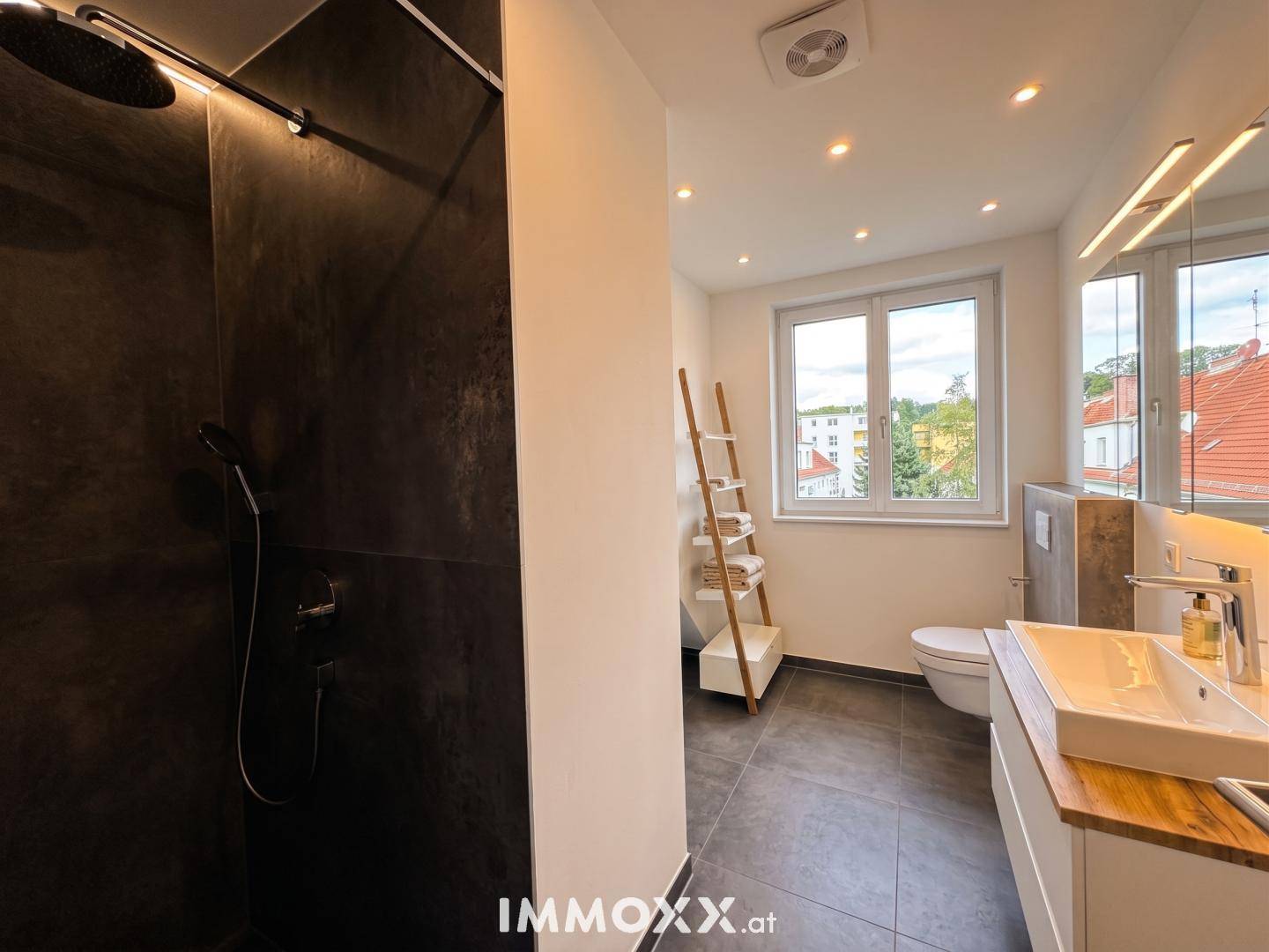 Modernes Badezimmer mit begehbarer Dusche, Einzelwaschbecken und einem Fenster für Tageslicht.