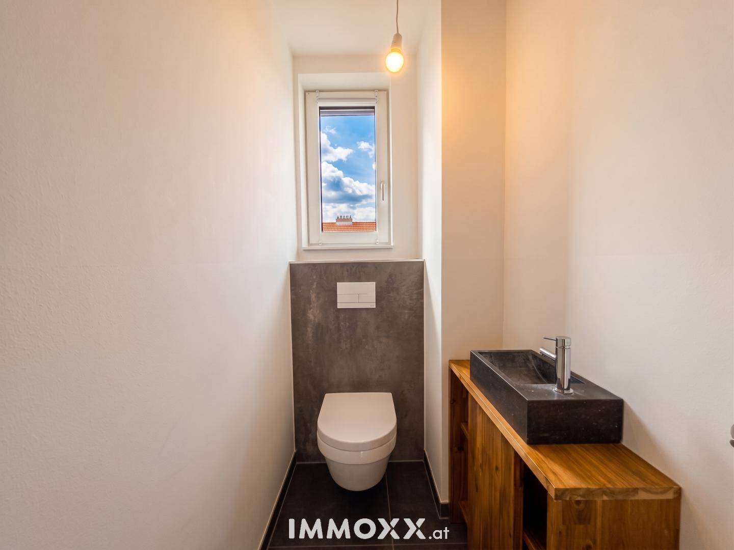 Modernes Gäste-WC mit wandhängender Toilette, einzigartigem Steinwaschbecken und Fenster.